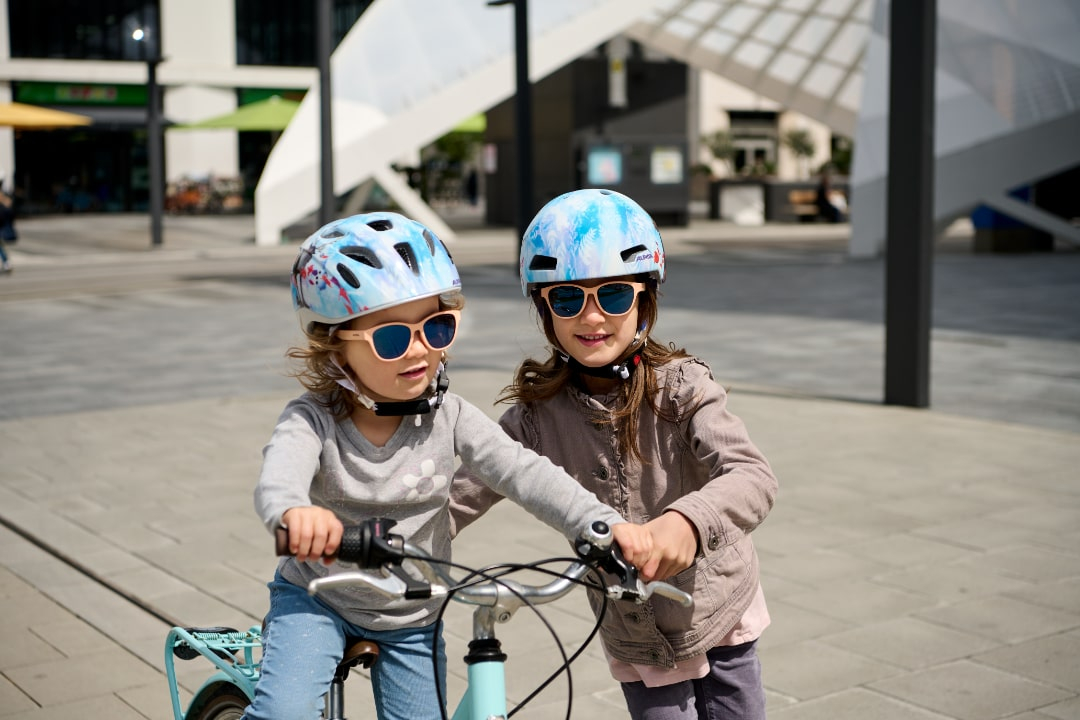 Kinder auf einem Fahrrad mit einem Alpina Kinderhelm