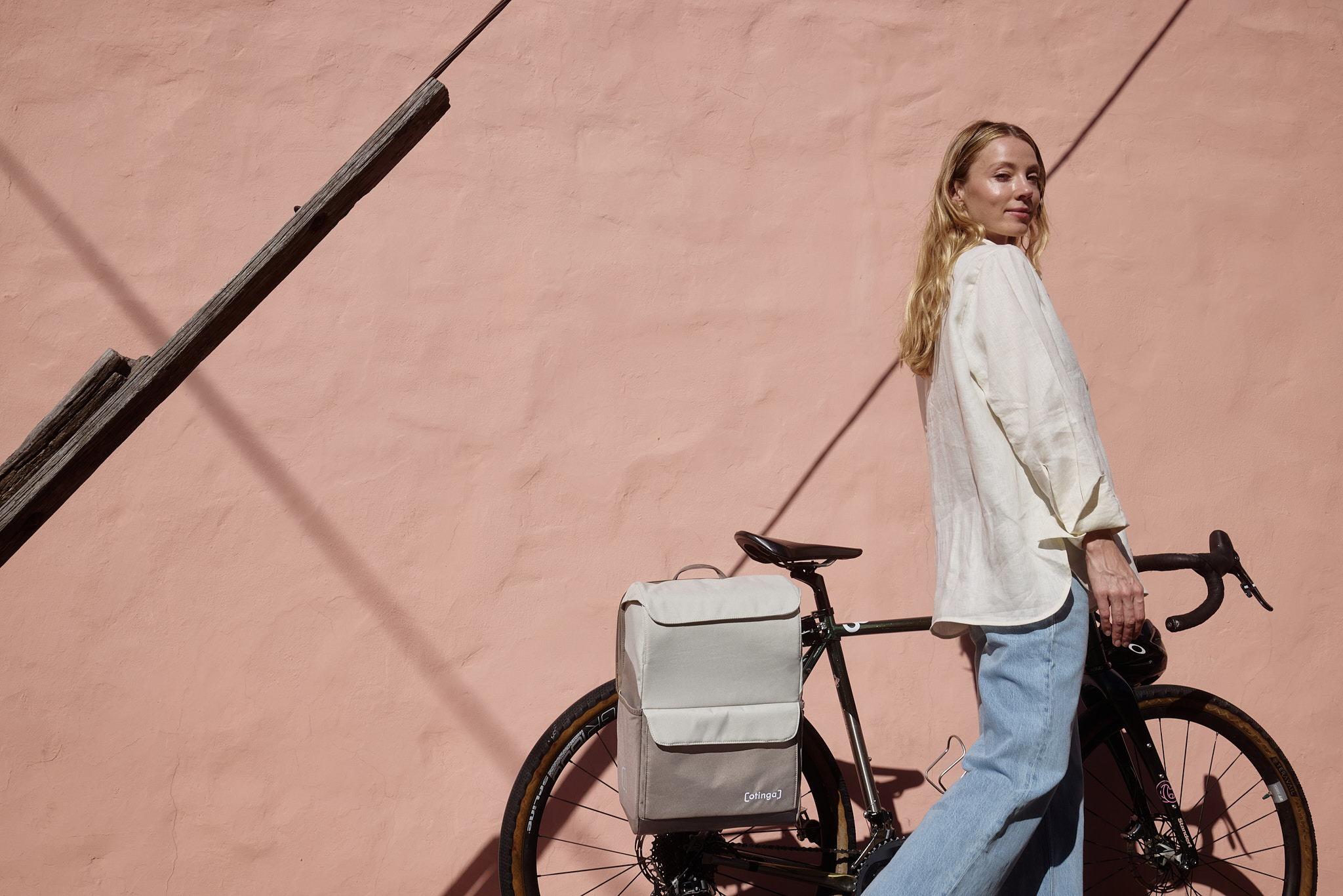Eine Person mit einem Fahrrad, an dem eine Radtasche der Marke otinga montiert ist.