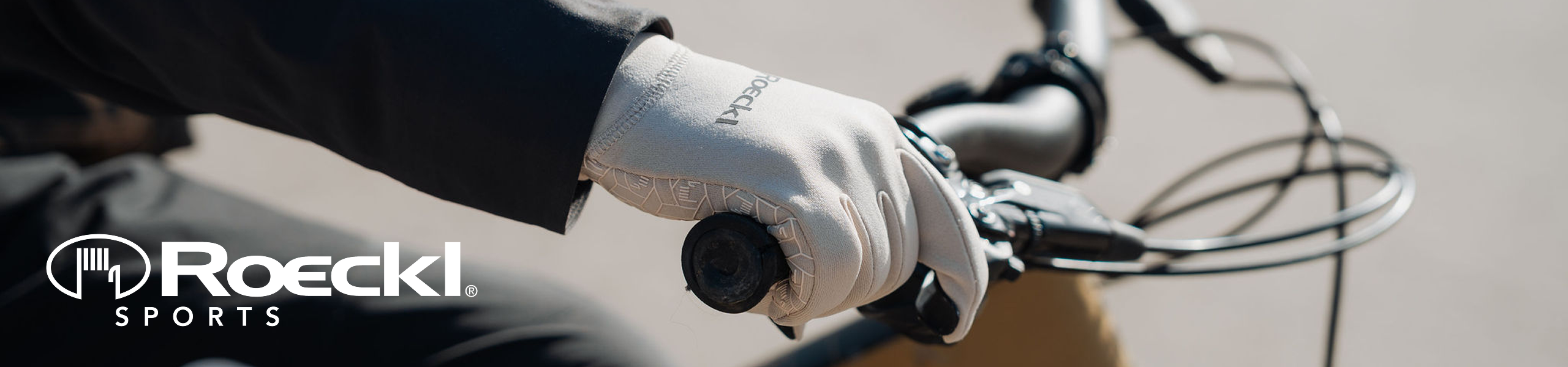 Roeckl Sports Markenseite - Fahrradfahrende Person mit weißen Roeckl Sports Handschuhen.